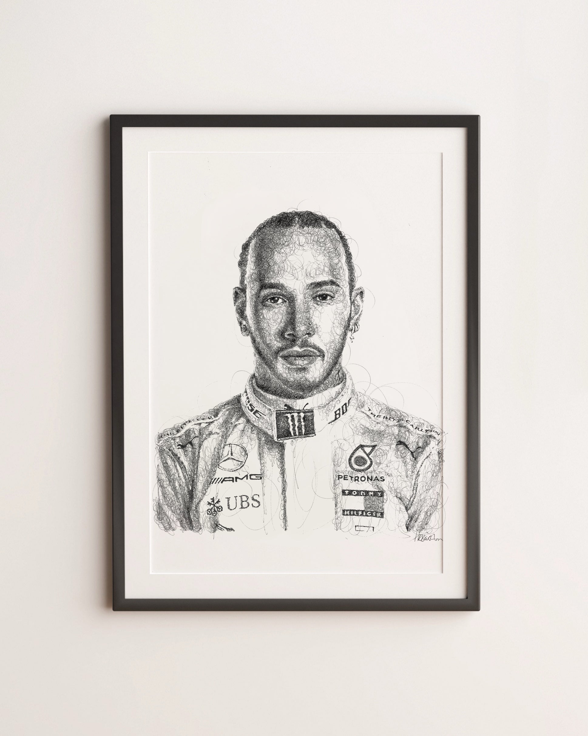 Framed black and white portrait of a Formula 1 driver Lewis Hamiltonn on a light gray wall